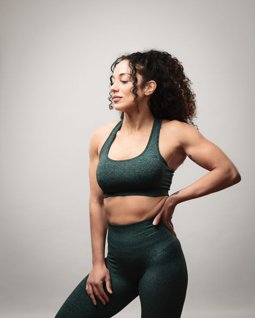 Woman in dark green athletic wear posing confidently