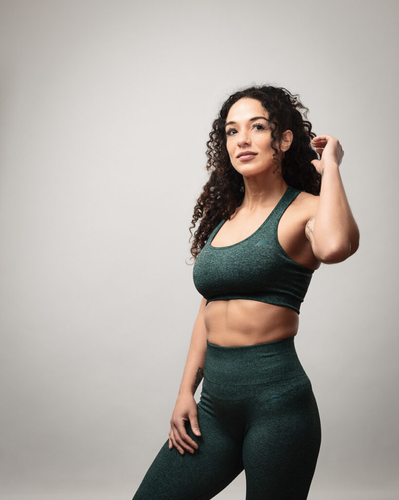 Confident woman in green activewear posing.