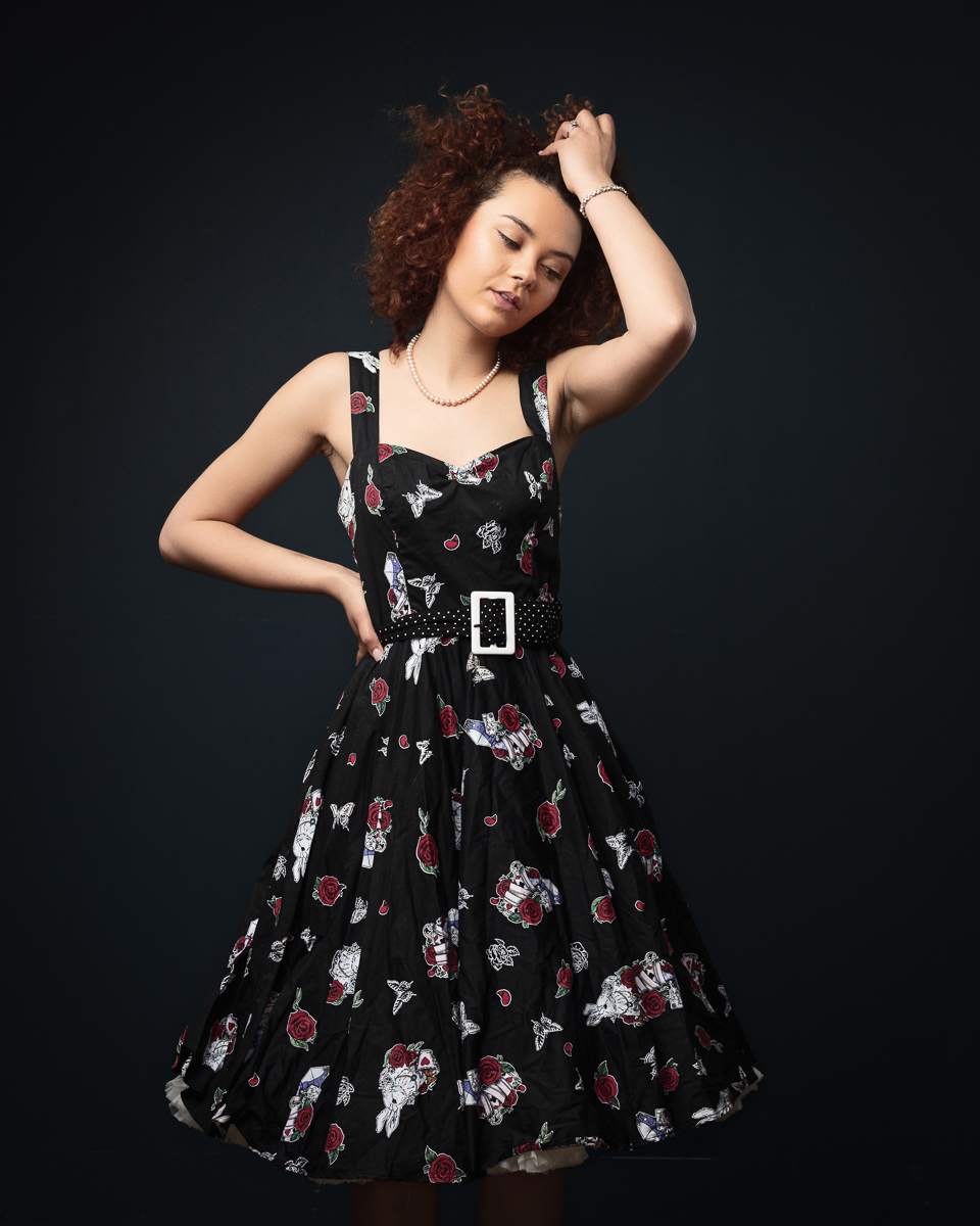 Woman in floral dress posing confidently.