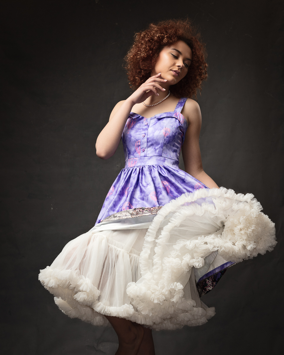 Woman in purple dress with white frilly skirt.