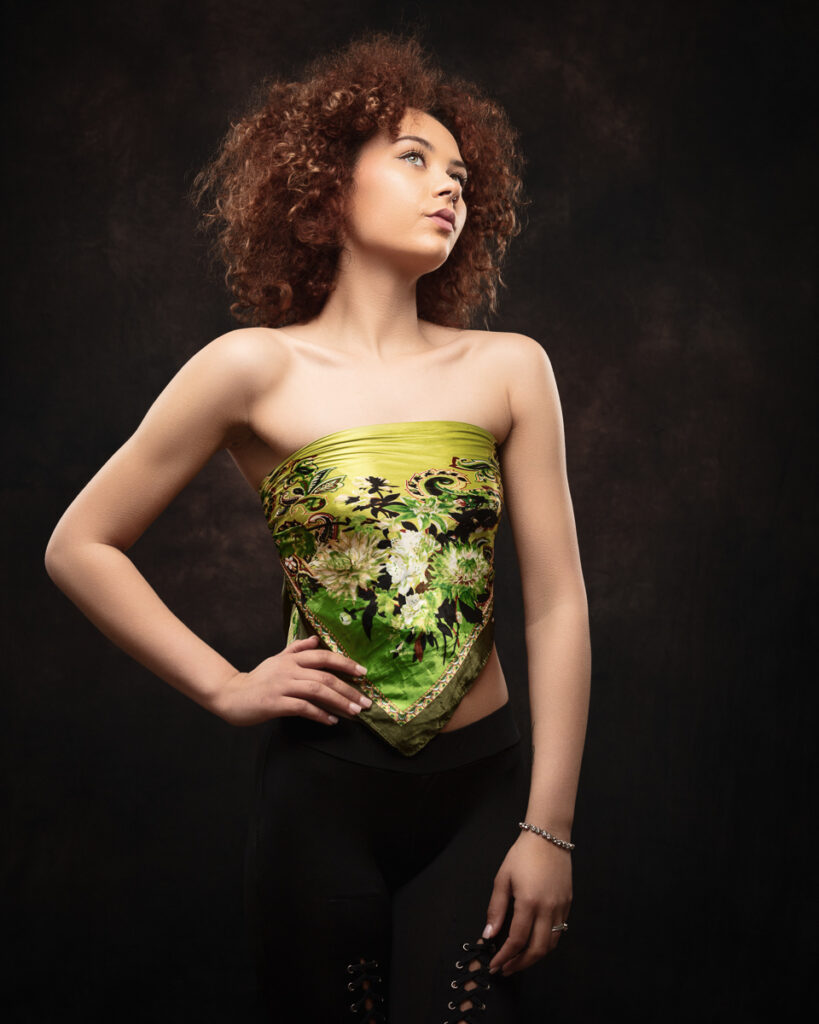 Woman wearing green patterned top, curly hair