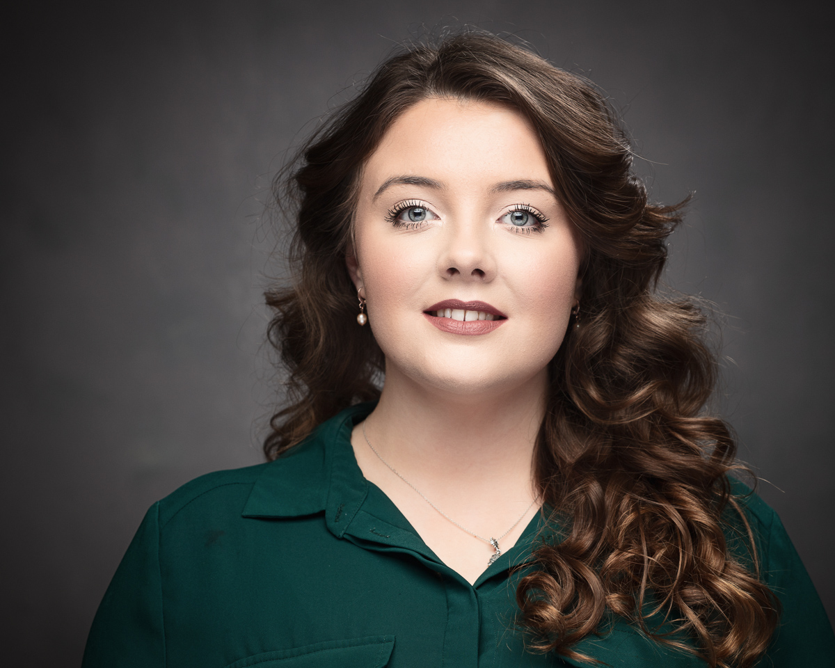Woman with curly hair, wearing green shirt