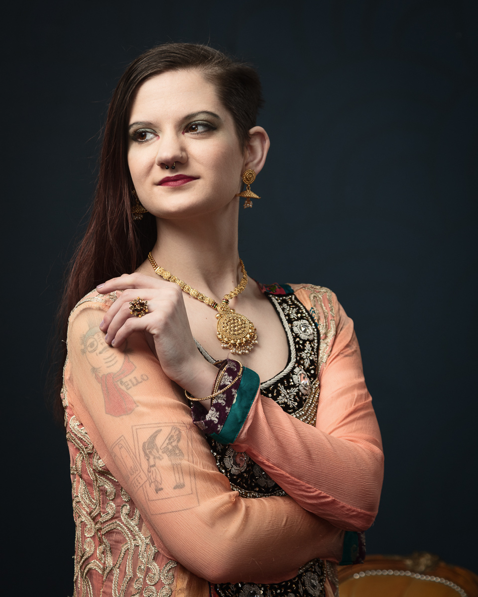 Woman in cultural dress with tattoos and jewellery.