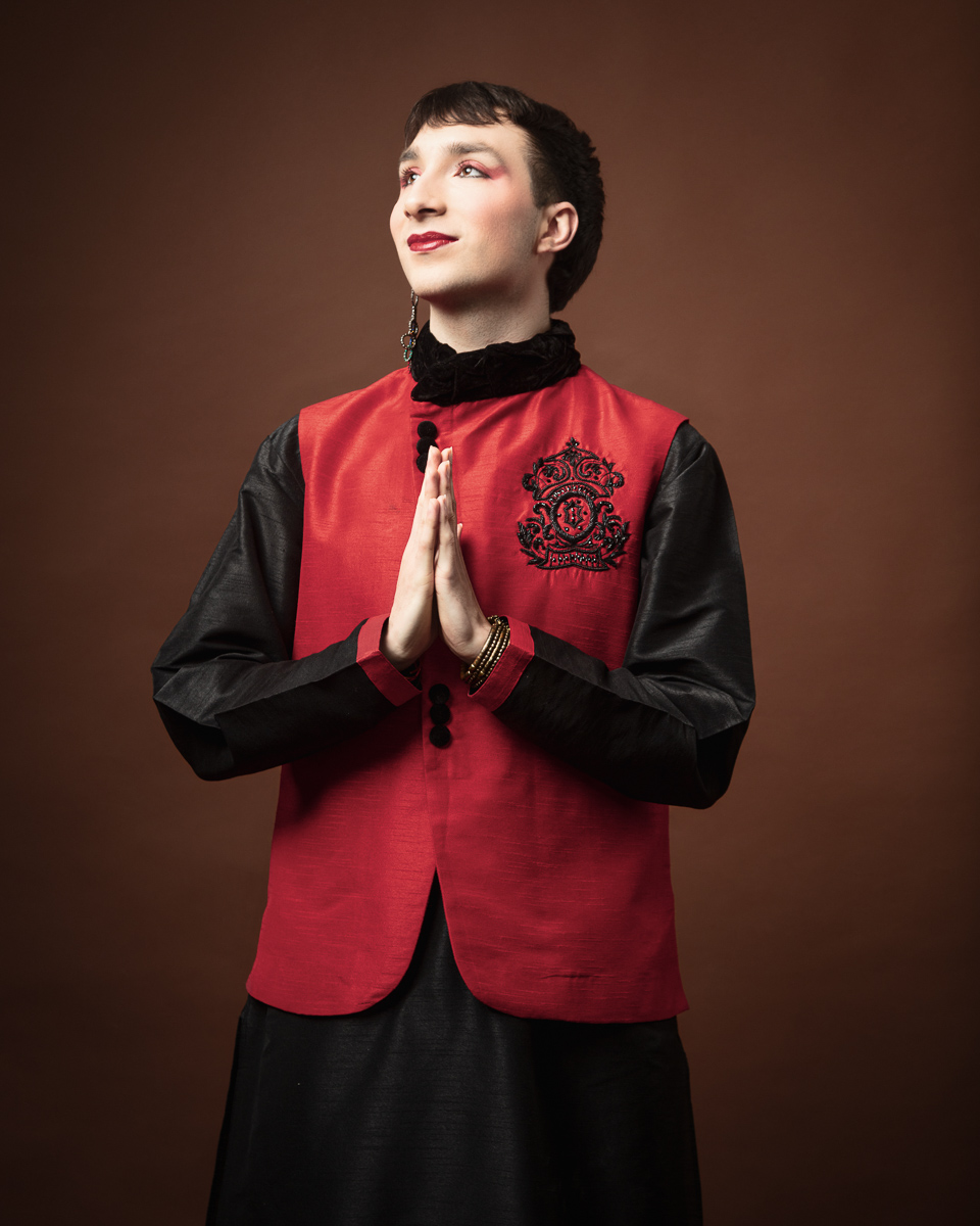 Person in red and black attire with makeup.