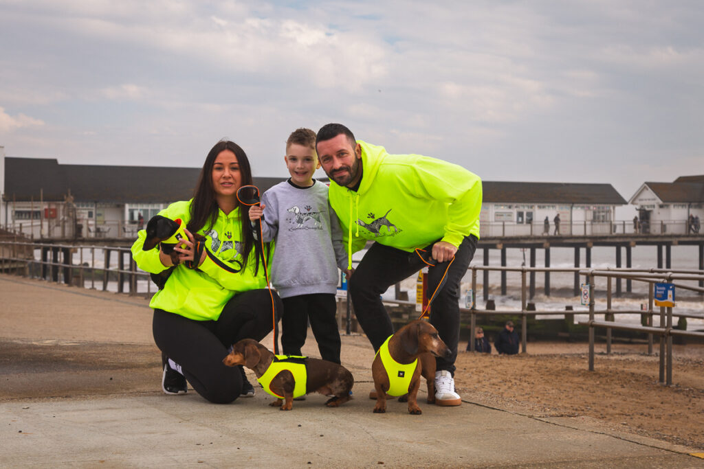 Family with sausages dogs enjoying seaside day