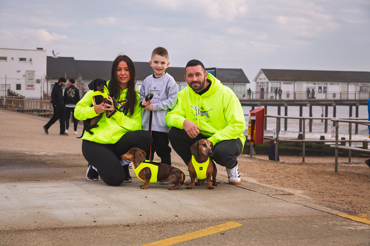 Family with dachshunds at seaside promenade