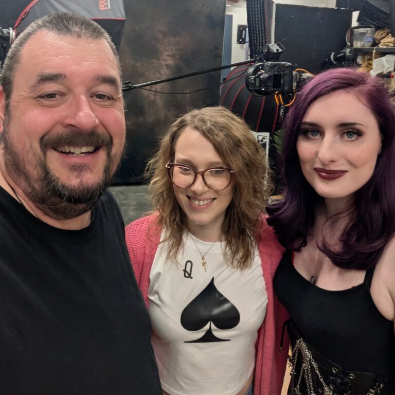 Three people smiling in a photography studio.