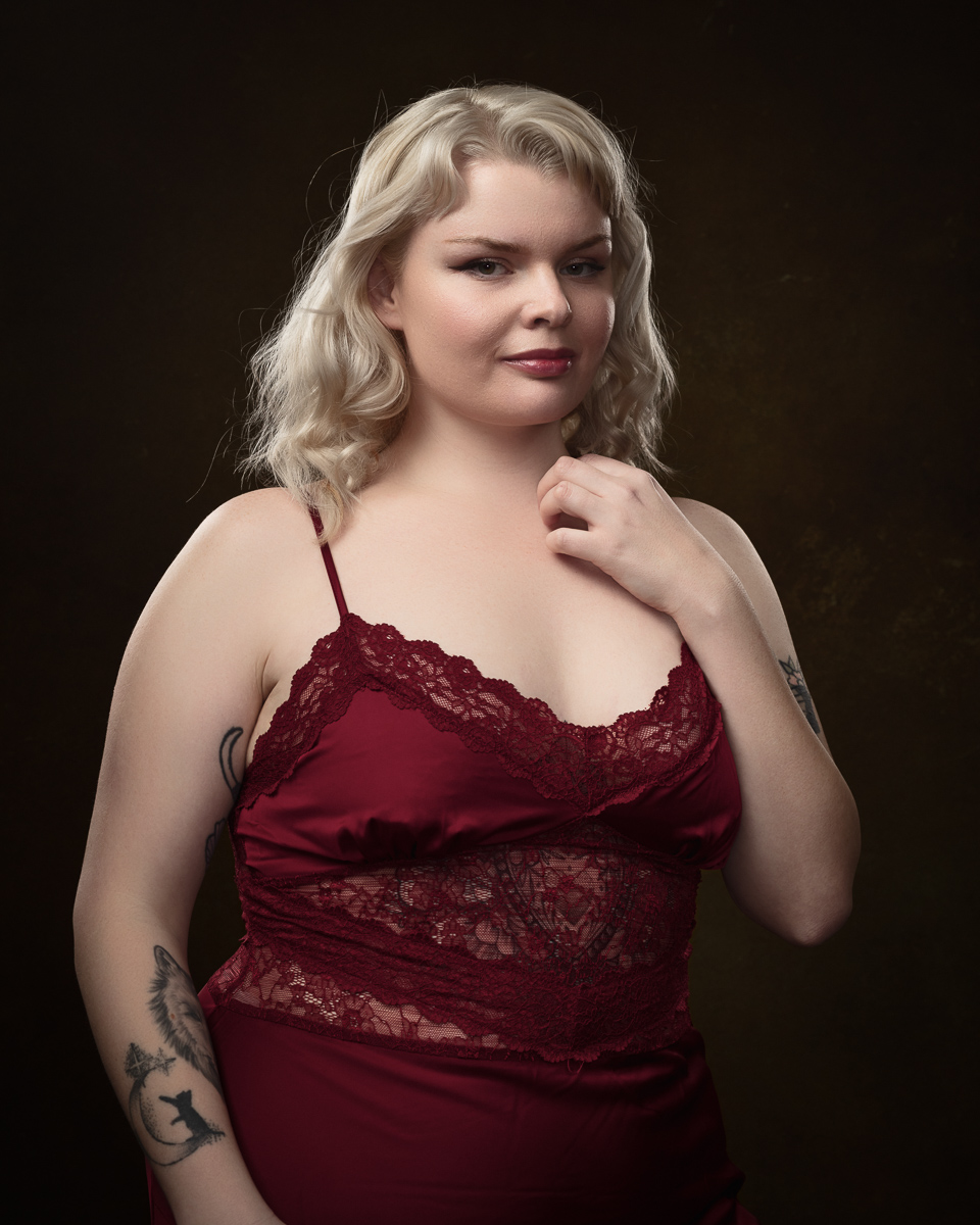 Person in red lace dress posing confidently.