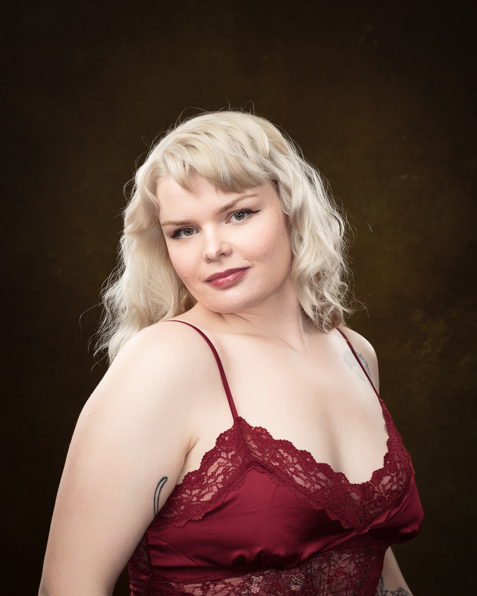 Person in red lace attire with blonde hair.