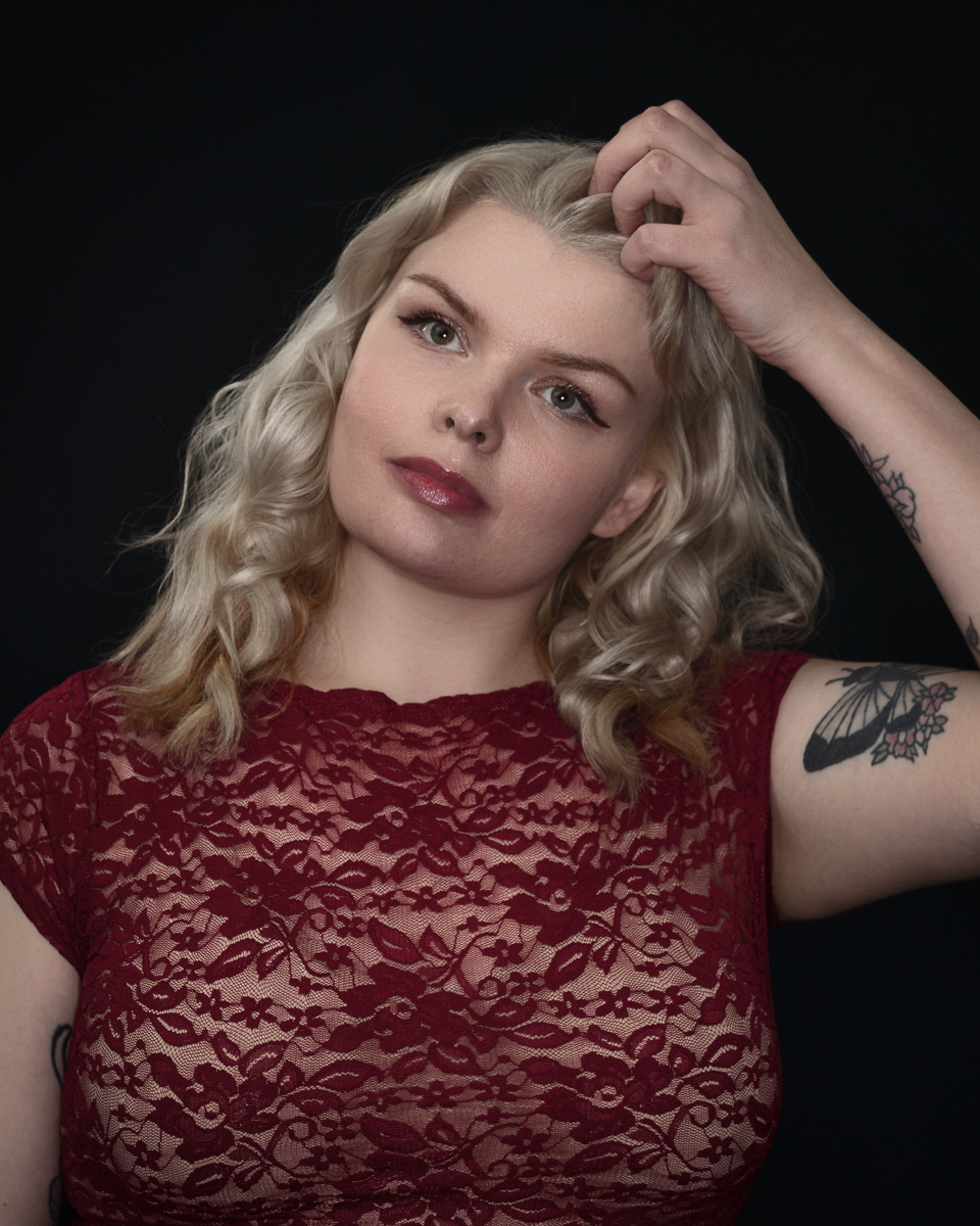 Woman in red lace dress touching hair