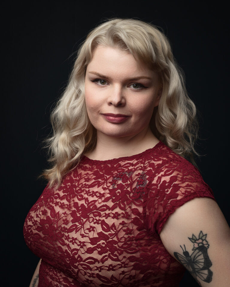 Person in red lace top with butterfly tattoo.