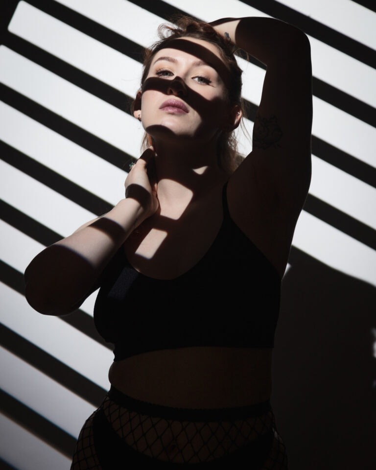 Dramatic shadows on woman's face and body