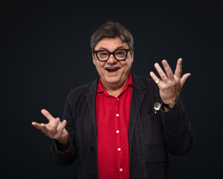 Man in red shirt gesturing happily.