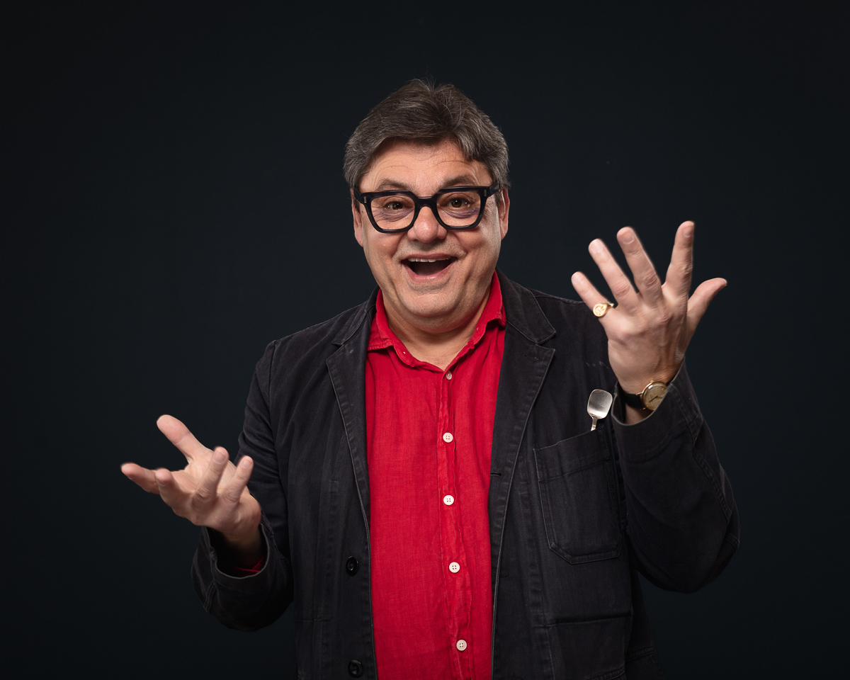 Man in red shirt gesturing happily.