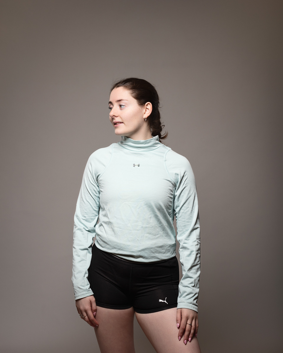 Person in activewear looking aside, grey background