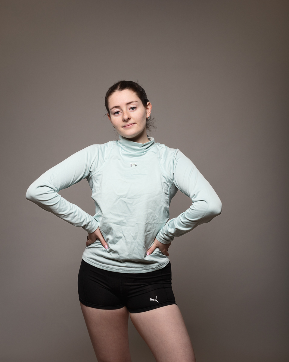 Person posing in athletic wear against grey background.