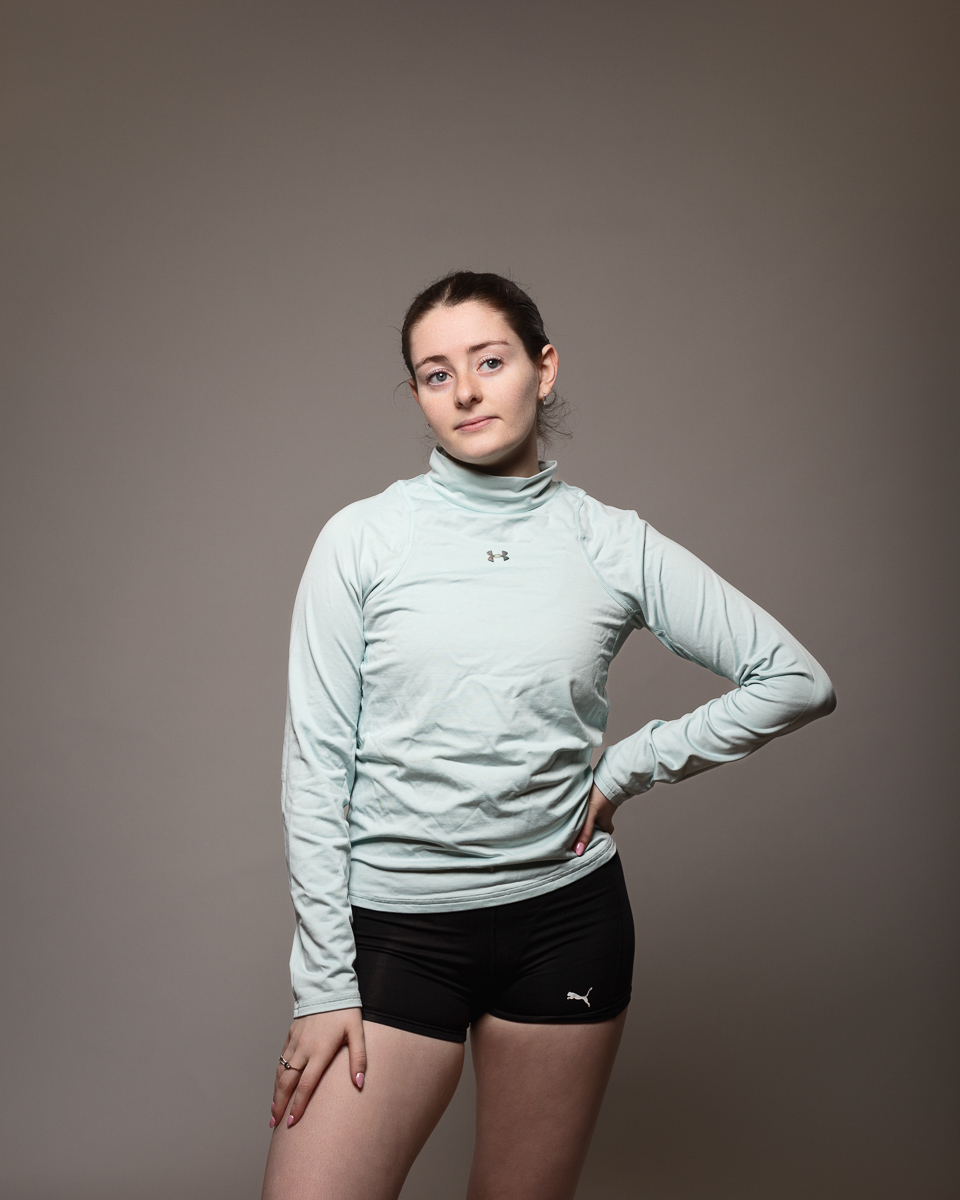 Person posing in sportswear against grey background.