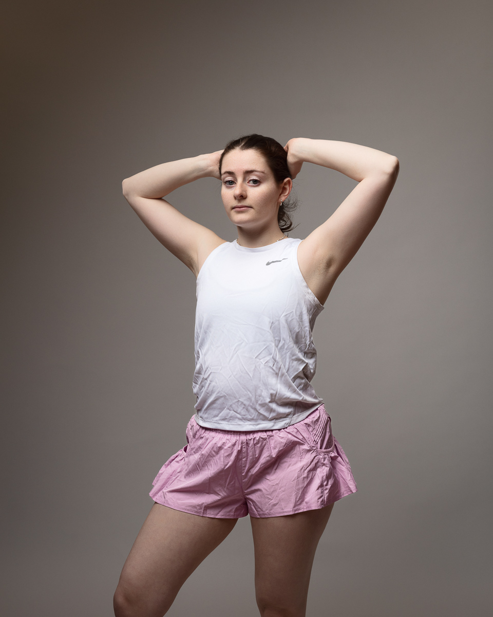Woman in sportswear posing confidently indoors.