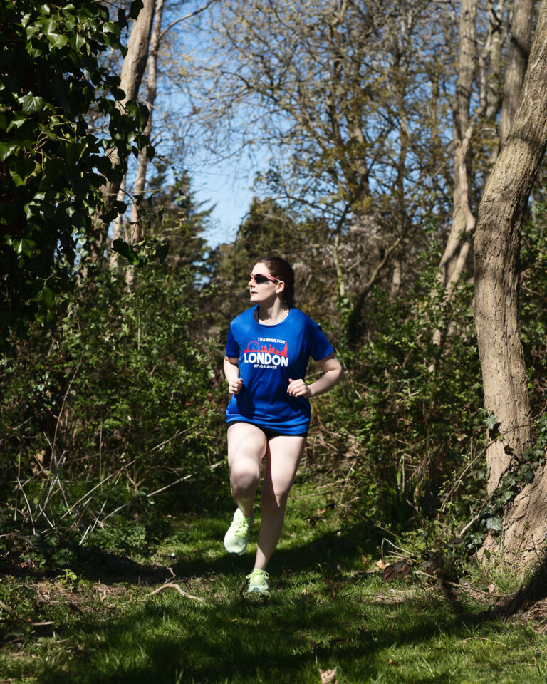 Woman jogging in woods, training for London marathon.