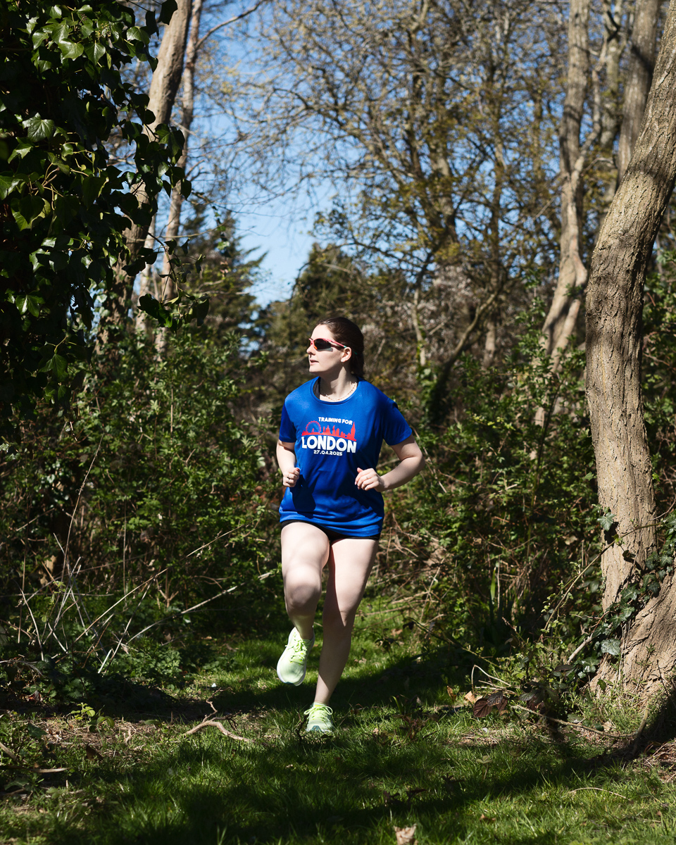 Woman jogging in woods, training for London marathon.