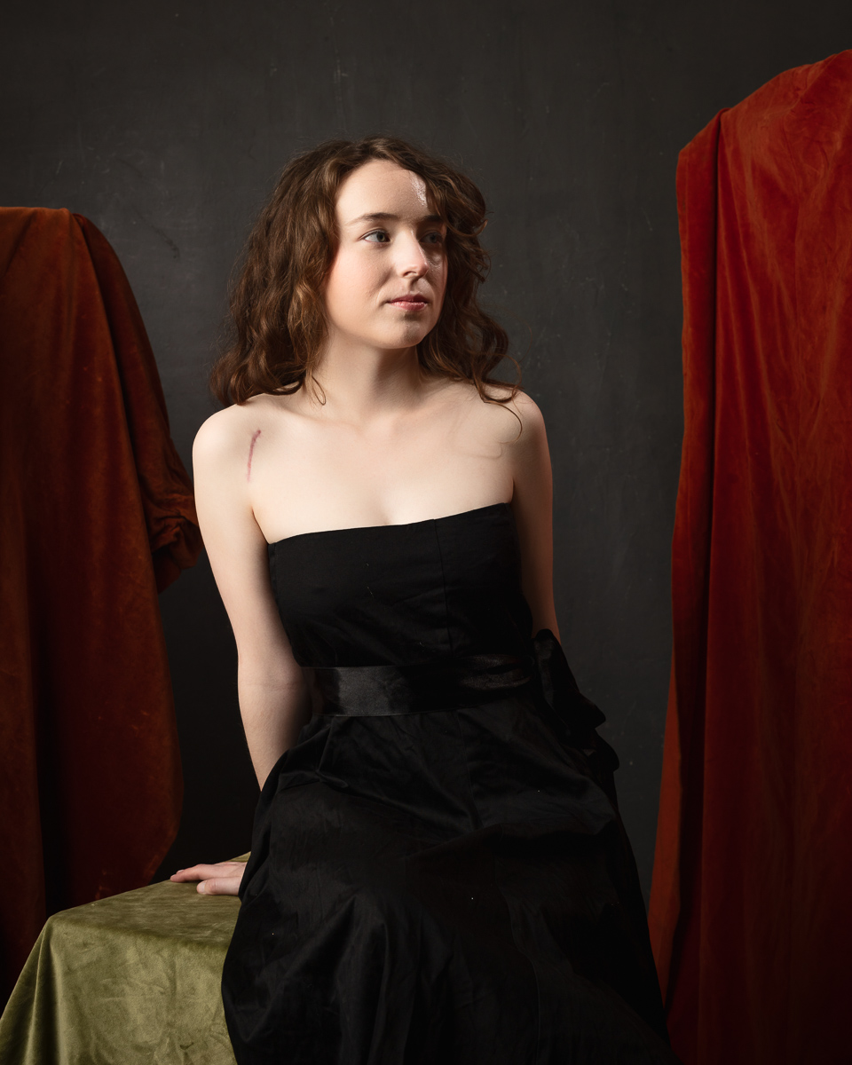Woman in black dress, artistic portrait with drapes.