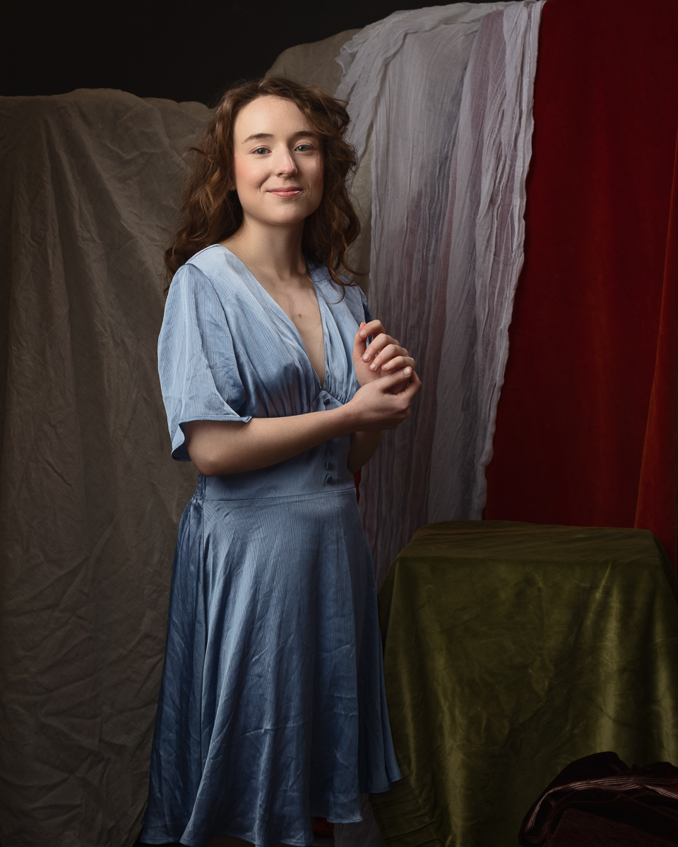 Woman in blue dress with draped background