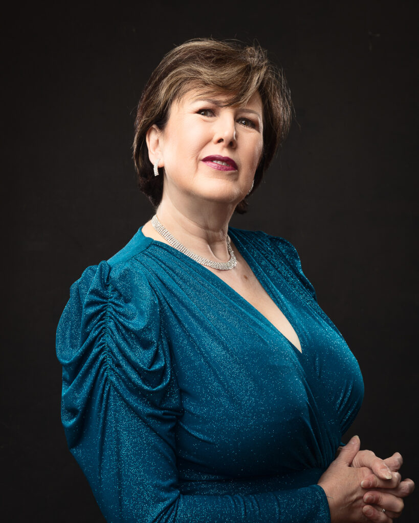 Woman in blue sparkling dress with necklace.
