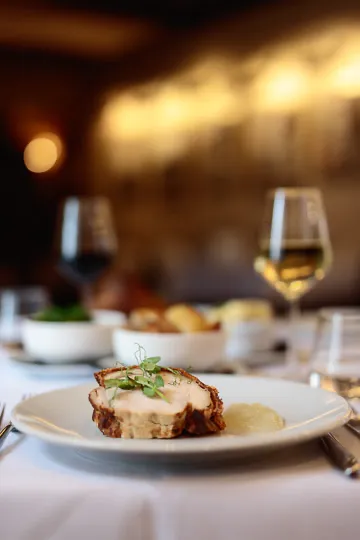 Gourmet meal with wine in elegant restaurant setting.
