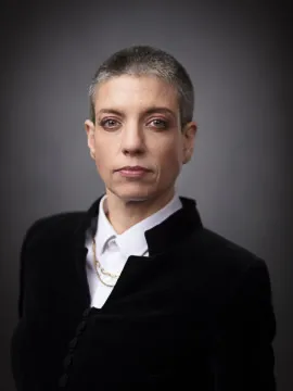 Confident person in formal attire with short hair