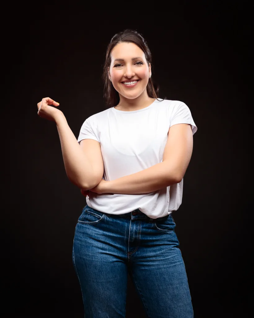 Smiling woman in casual white top and jeans.
