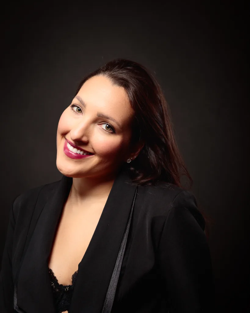 Smiling woman in a black blazer portrait.