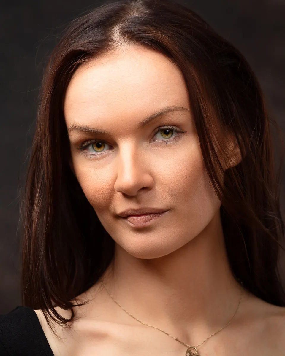 Portrait of woman with brown hair and neutral expression.