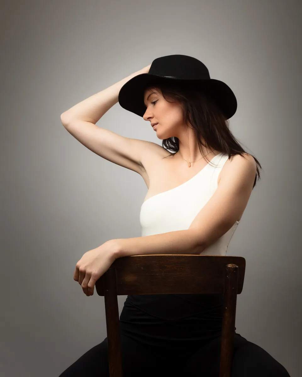 Person seated in profile wearing black hat.