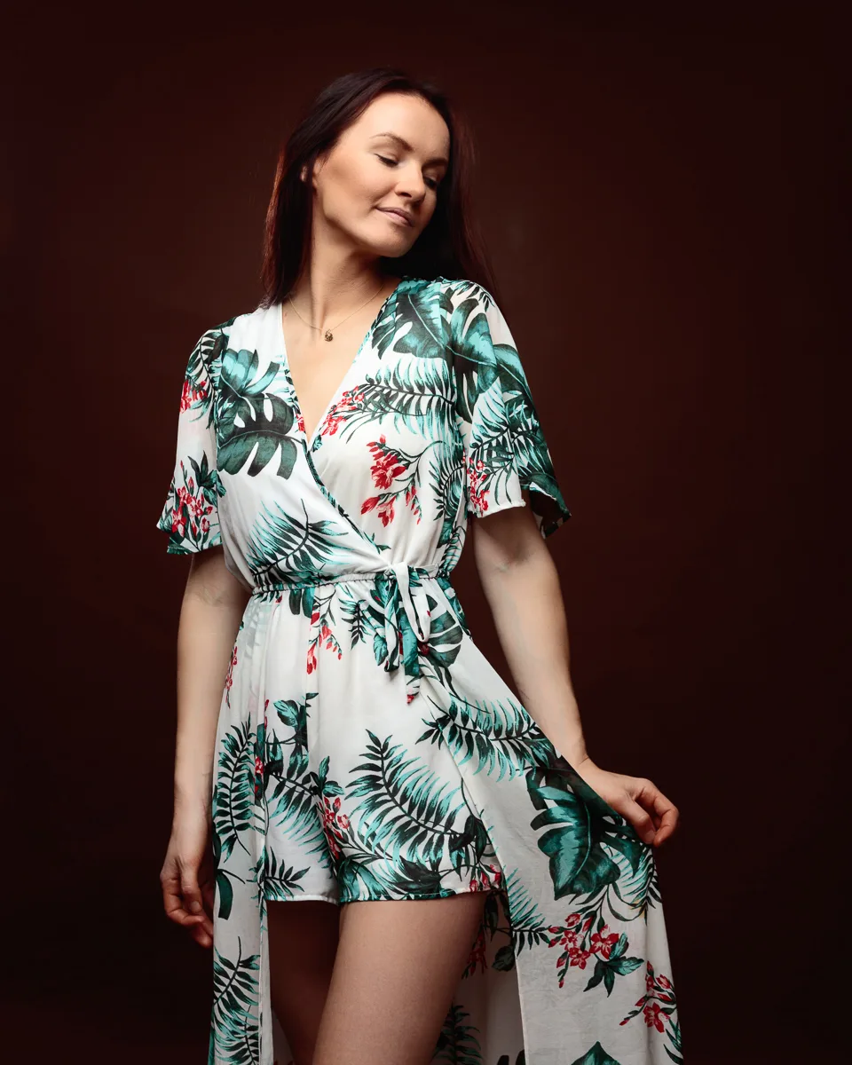 Woman in floral dress against dark background