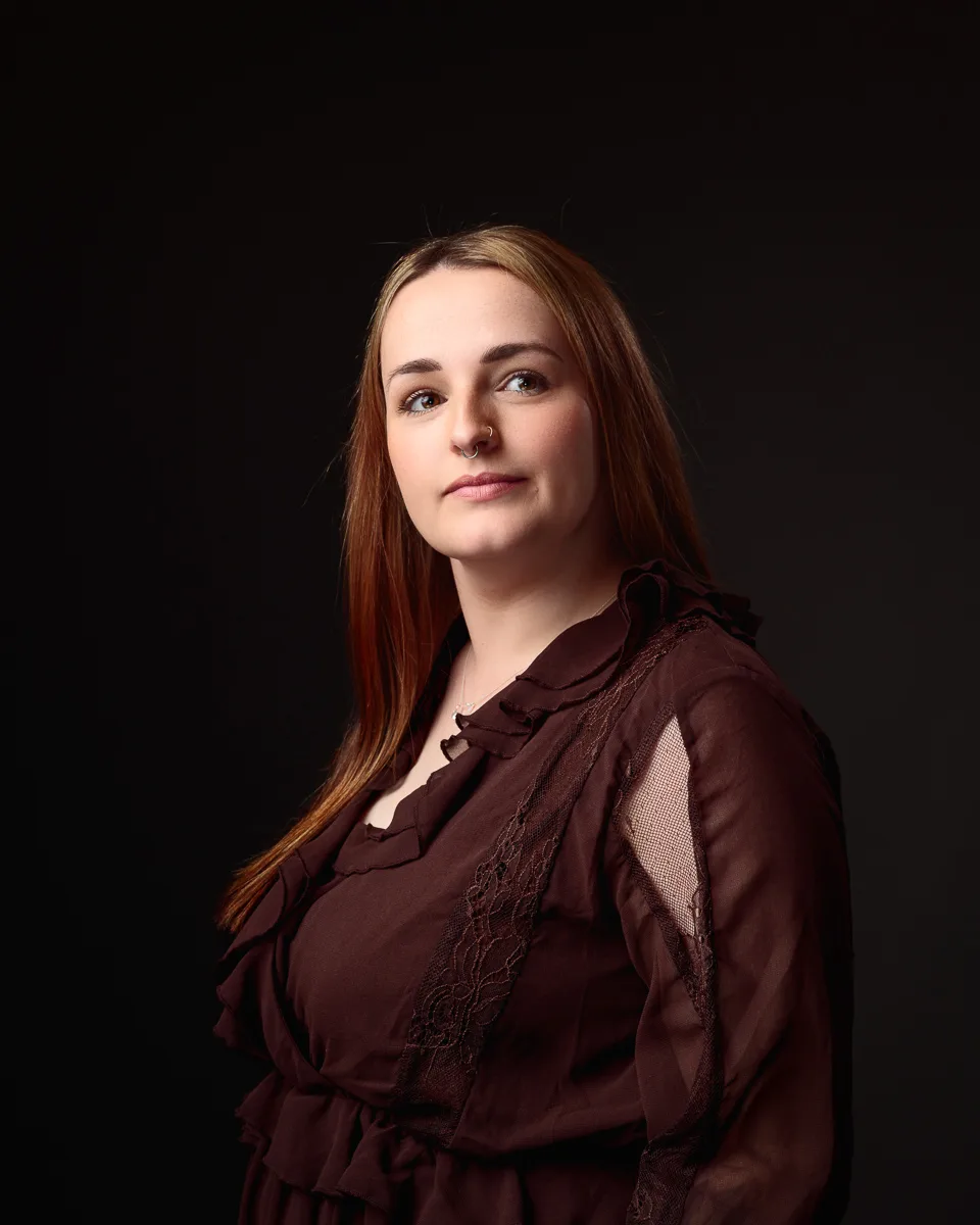 Woman in brown dress against dark background