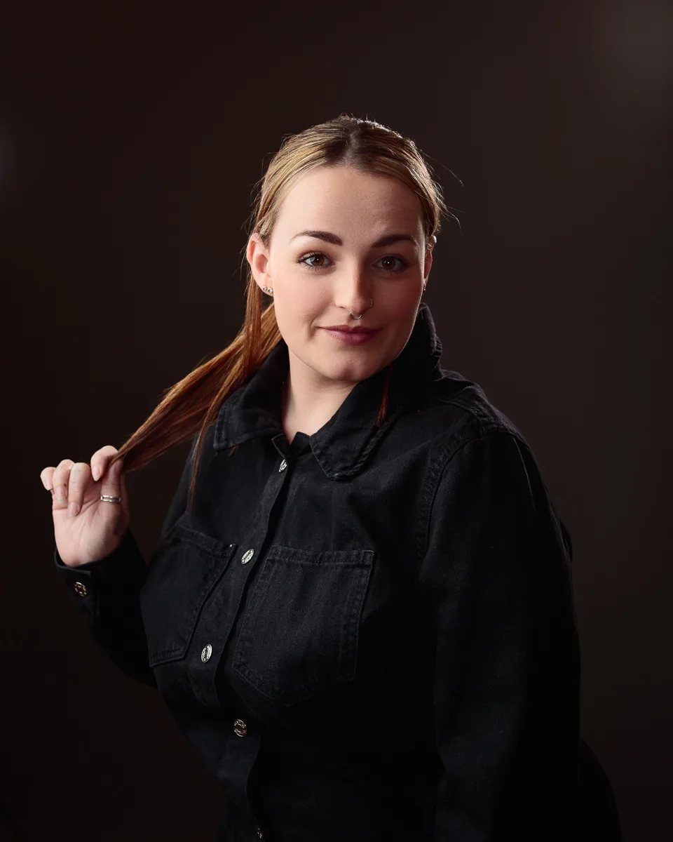 Woman in black shirt with thoughtful expression.