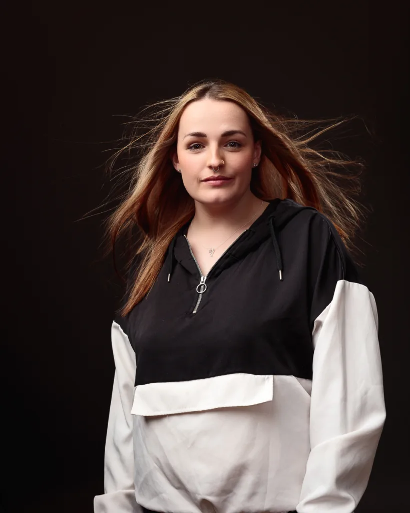 Person with flowing hair wearing black and white top.