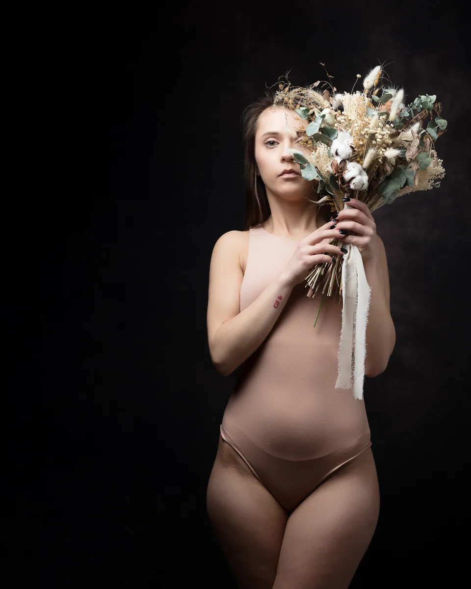 Woman holding bouquet against dark background