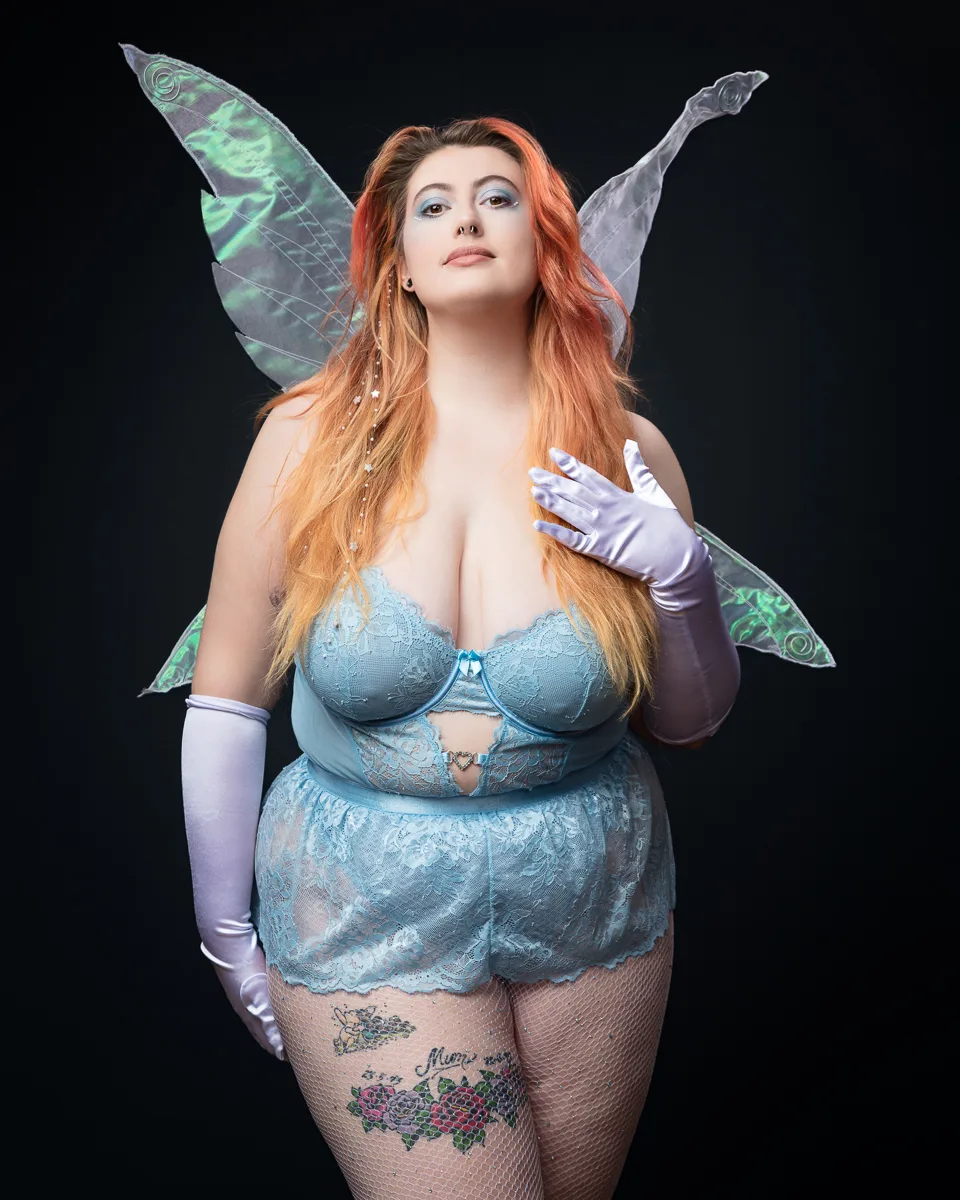 Person in fairy costume on dark background.