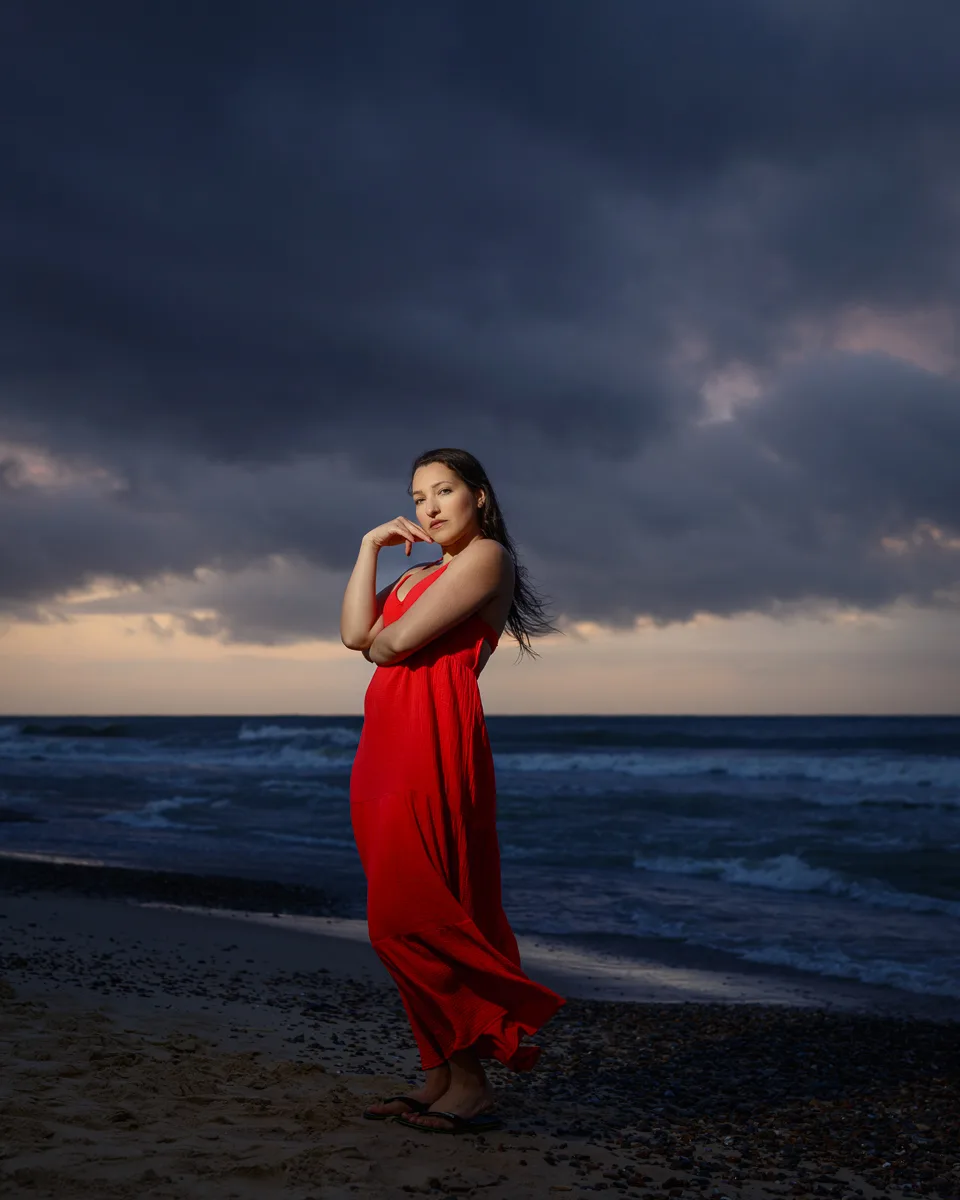 Woman in red dress on stormy beach