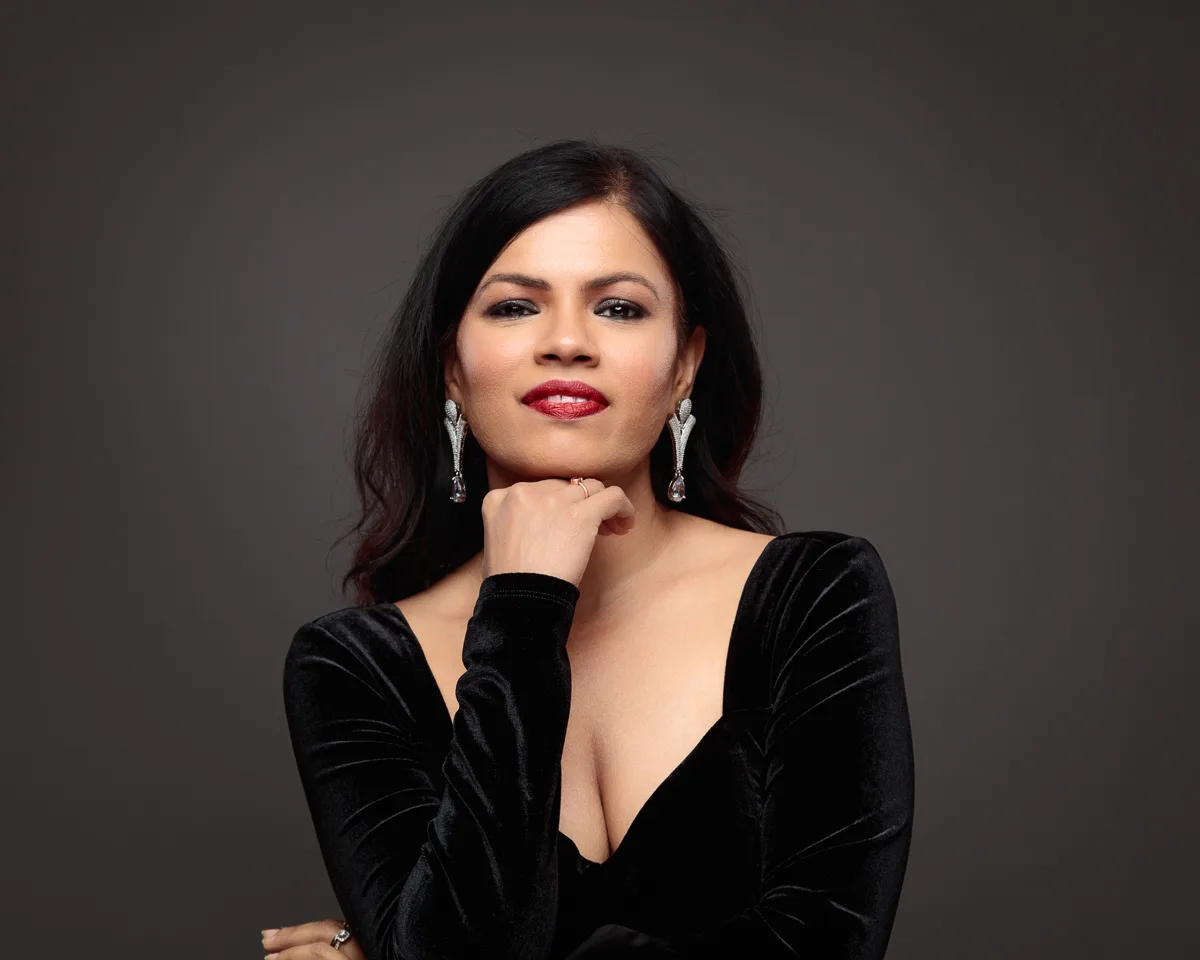 Woman in black dress with elegant earrings.