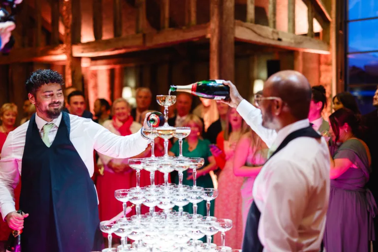 Champagne being poured into a pyramid of glasses.