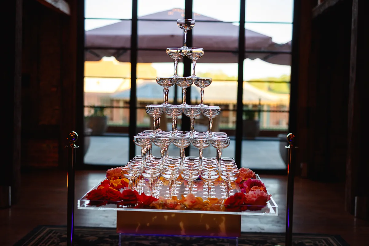 Champagne glass tower with floral decoration.
