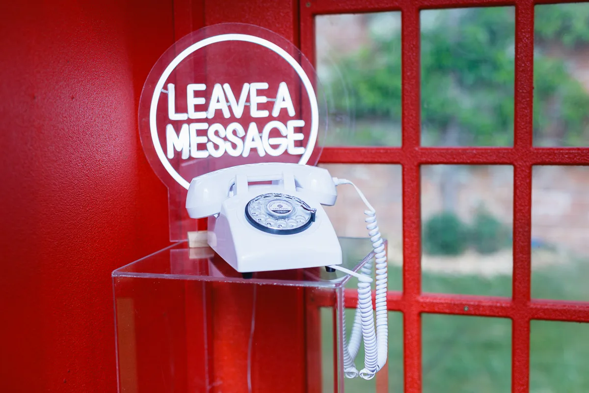 White rotary phone with leave a message sign