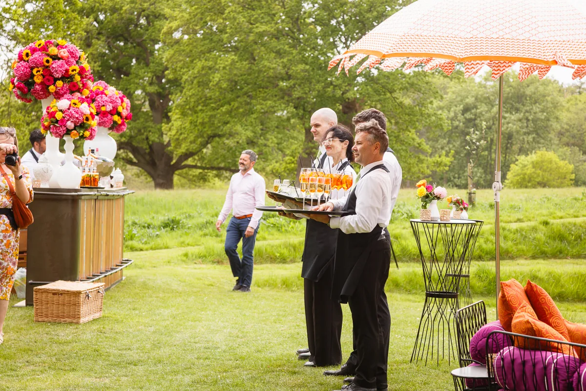 Outdoor garden party with drinks and floral decorations.