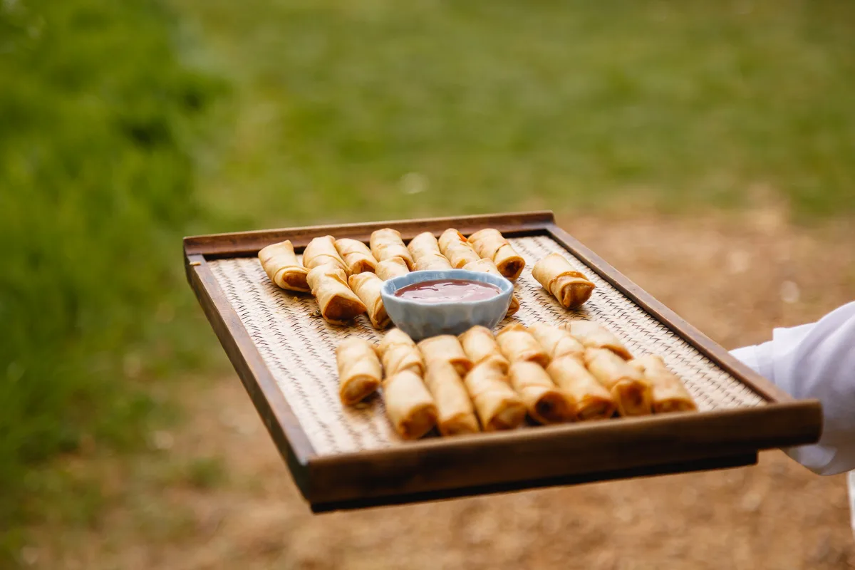 Tray of spring rolls with dipping sauce.