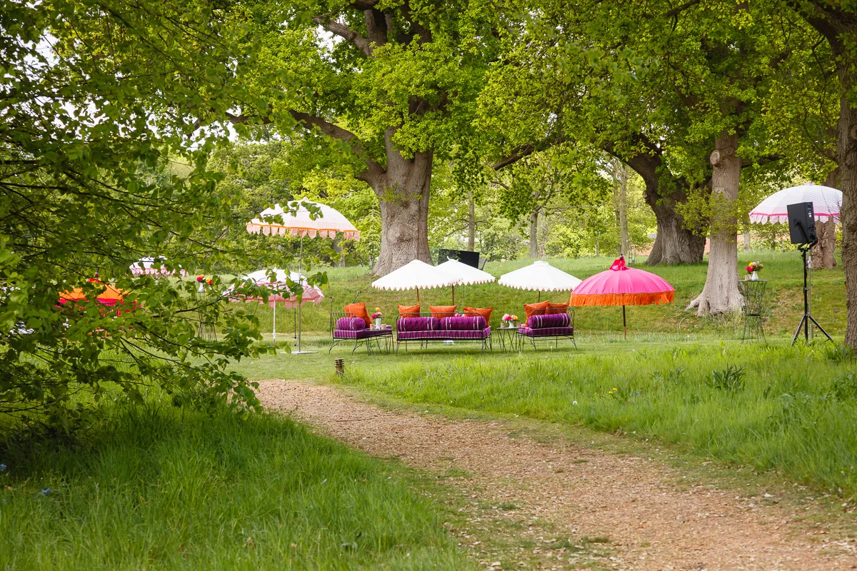 Colourful outdoor seating arrangement under trees.