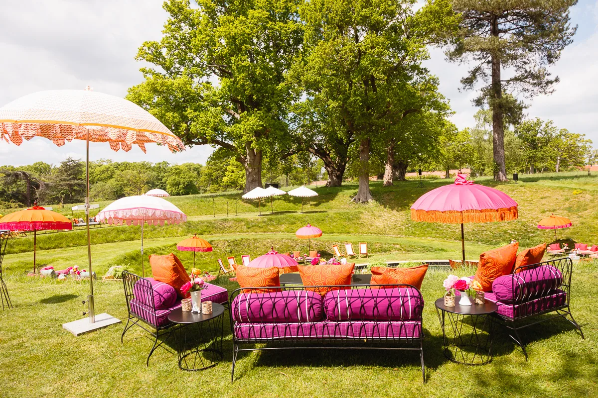 Colourful garden seating under umbrellas, sunny day.