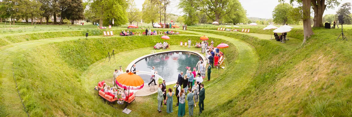 Outdoor pool party with guests and parasols.