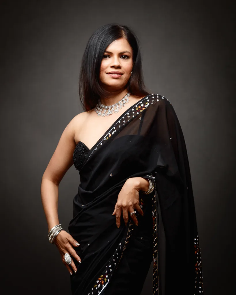 Woman in elegant black sari and silver jewellery.